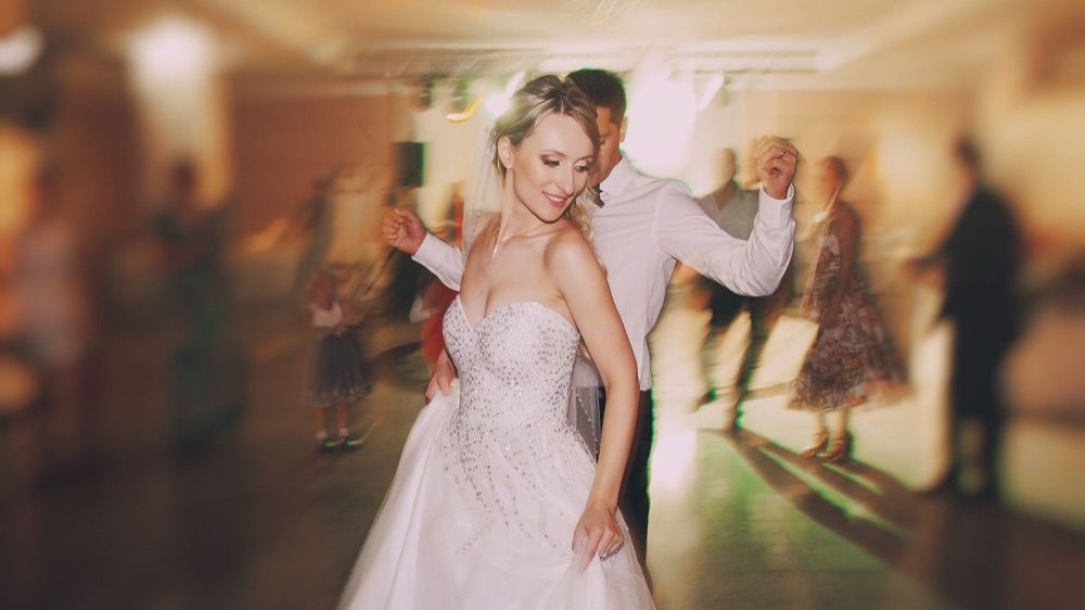 A bride and groom mid-turn during their first dance at the reception