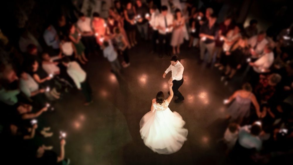 Newlyweds dancing their first dance, ringed by guests holding sparklers